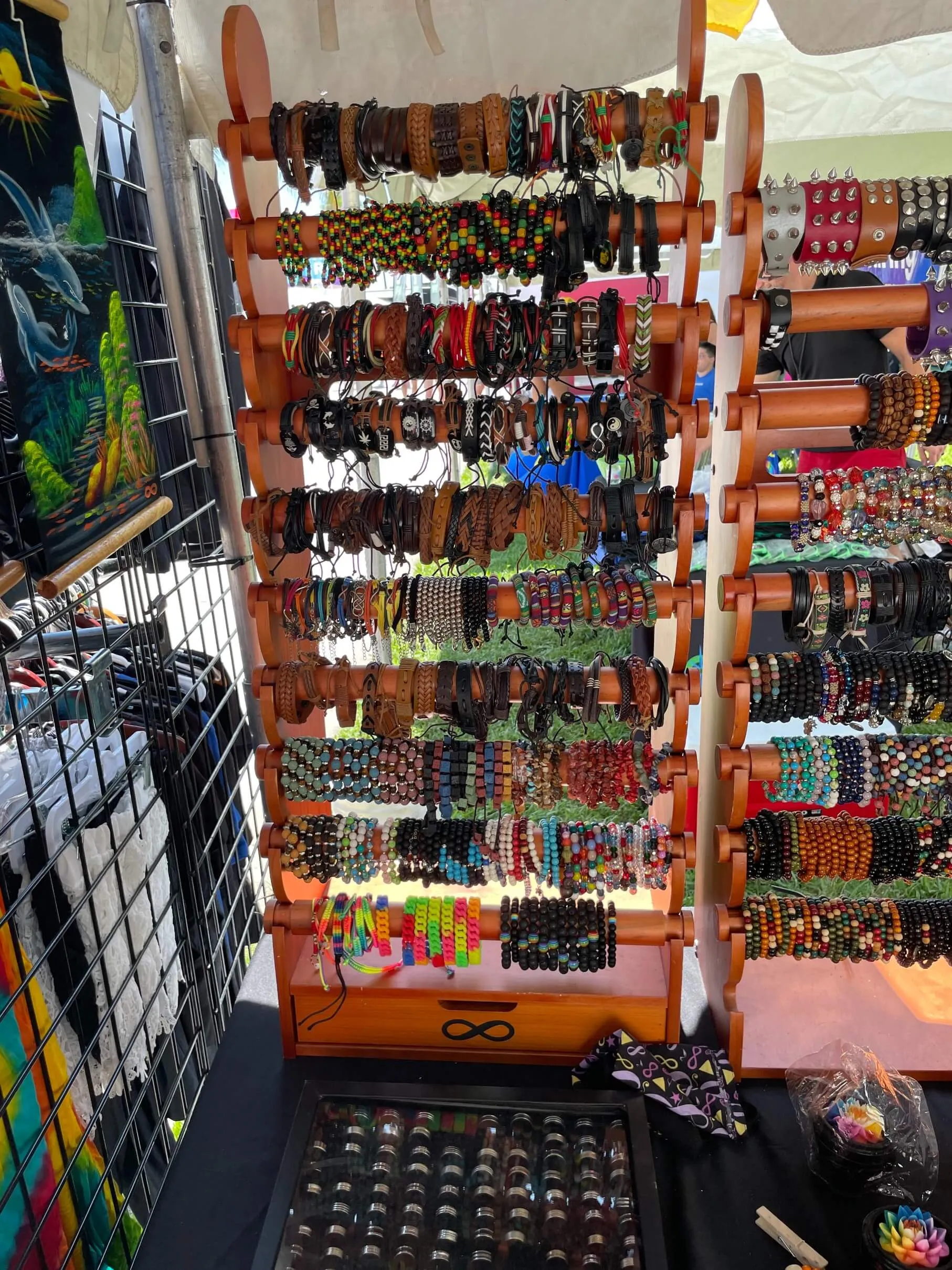 A Giant bracelet display fully loaded with hundreds of colorful bracelets at an outdoor festival booth